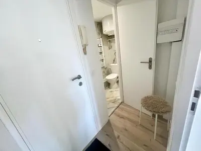 a small white bathroom with a toilet and a stool at Studio Moderne Rénové avec balcon in Nice