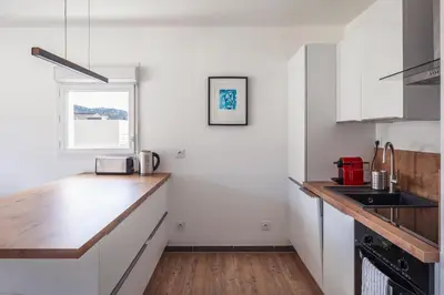 a kitchen with white walls and a wooden counter top at Appartement in Carros