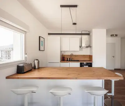 a kitchen with a wooden counter top and stools at Appartement in Carros