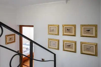 a staircase with framed pictures on a wall at #15 Sea front Villa AC stunning view for 6 pers wifi in Nice