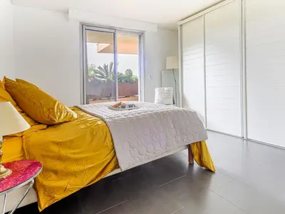 a bedroom with a bed with a yellow blanket and a window at Apartment Les Balcons d'Eze-3 by Interhome in Èze