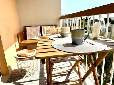 a living room with a mirror and a white wall at Joli 2 pièces - Proche aéroport - Terrasse vue mer in Nice