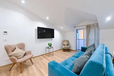 a living room with a blue couch and two chairs at Trois pièces cozy n14 in Nice