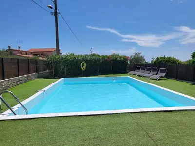a swimming pool in a yard with two chairs at Superbe bas de Villa au calme in Cagnes-sur-Mer