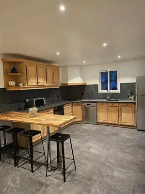 a large kitchen with a wooden table and chairs at Superbe bas de Villa au calme in Cagnes-sur-Mer