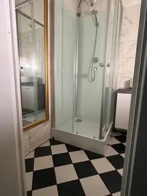 a glass shower in a bathroom with a checkered floor at Appartement Nice Port Lympia Wifi Top Location in Nice