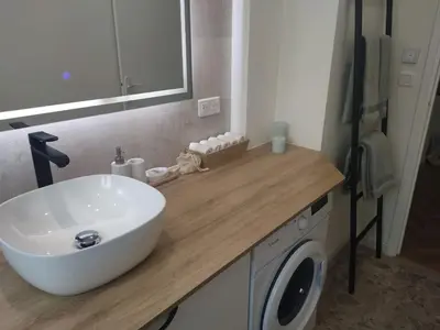 a bathroom with a sink and a washing machine at Bel appartement - plage à 50 m in Nice