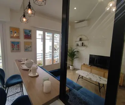 a dining room with a table and a living room at Bel appartement - plage à 50 m in Nice