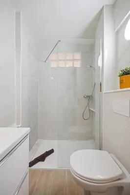 a white bathroom with a toilet and a shower at Le Mistral in Nice