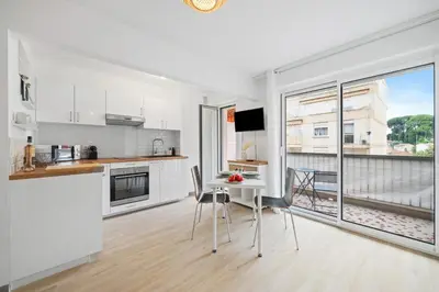 a kitchen with white appliances and a table with chairs at Le Mistral in Nice