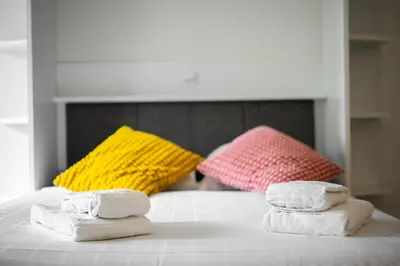 three towels sitting on top of a bed with pillows at Le Mistral in Nice