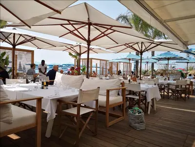 a restaurant with white tables and chairs and umbrellas at Luxury apartment on Promenade des Anglais in Nice in Nice