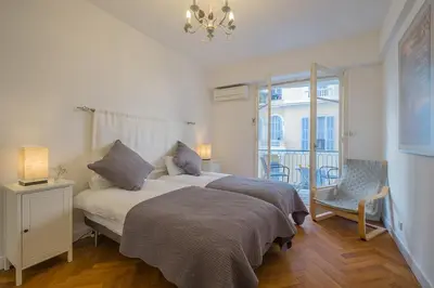a bedroom with a bed and a chair and a window at Luxury apartment on Promenade des Anglais in Nice in Nice