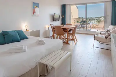 a bedroom with a large bed and a table and chairs at L20 Stunning sea view, terrace, parking, AC, Wifi in Nice