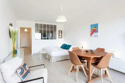 a living room with a table and a bed at L20 Stunning sea view, terrace, parking, AC, Wifi in Nice