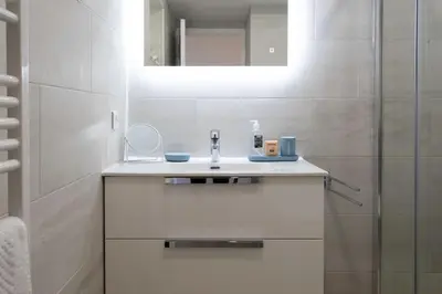 a white bathroom with a sink and a mirror at L20 Stunning sea view, terrace, parking, AC, Wifi in Nice
