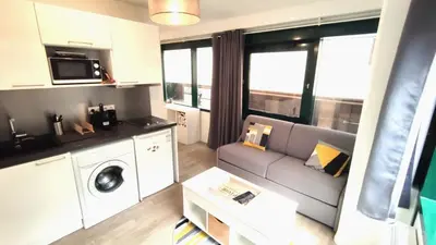 a living room with a couch and a washing machine at Dana centre mer 25 in Nice
