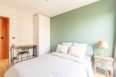 a bedroom with a white bed and a chair at Charmant appartement à Nice in Nice