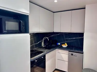 a kitchen with white cabinets and a microwave at Charmant appartement à Nice in Nice