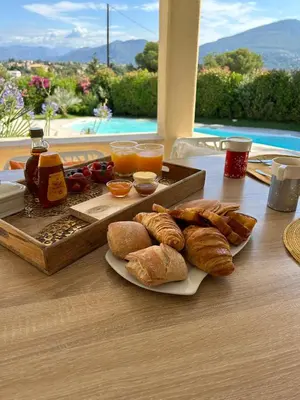 a table with a tray of bread and pastries on it at Duplex Oliveraie piscine au sel marin et parking in Nice