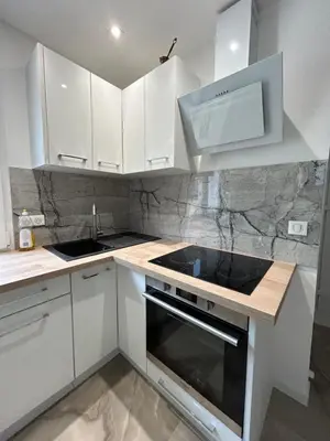 a kitchen with a large window with a table and chairs at Duplex Oliveraie piscine au sel marin et parking in Nice