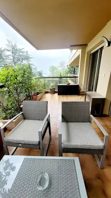 a room with two chairs and a table and a balcony at Duplex Apartment, Sea View and Swimming Pool in Nice