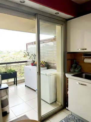 a kitchen with a sliding glass door to a refrigerator at Duplex Apartment, Sea View and Swimming Pool in Nice