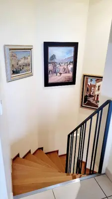 a staircase with three paintings on the wall at Duplex Apartment, Sea View and Swimming Pool in Nice