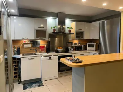 a kitchen with white cabinets and stainless steel appliances at Duplex Apartment, Sea View and Swimming Pool in Nice