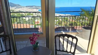 a room with a window with two chairs and a table at Chambre d'hôtes pleine vue mer in Nice