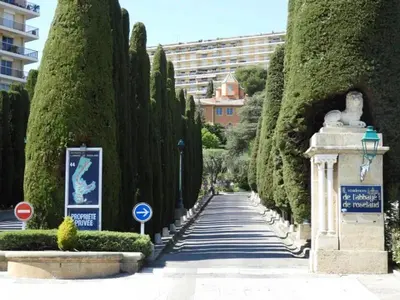 a walkway through a row of trees in a park at Chambre d'hôtes pleine vue mer in Nice