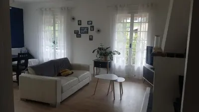 a living room with a white couch and a table at chez steph in La Trinité