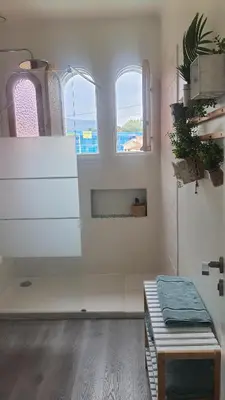 a white room with two windows and a white dresser at chez steph in La Trinité