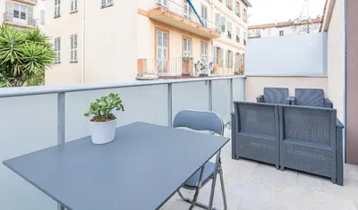 a table and chairs on the balcony of a building at Studio cozy avec terrasse n12 in Nice