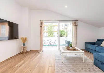 a living room with a blue couch and a table at Studio cozy avec terrasse n12 in Nice