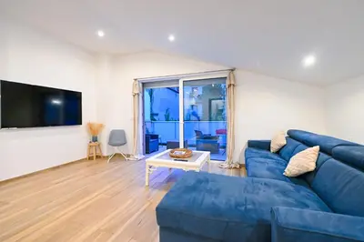 a living room with a blue couch and a table at Studio cozy avec terrasse n12 in Nice