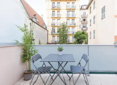 a table and chairs on the balcony of a building at Studio cozy avec terrasse n12 in Nice