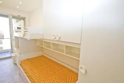 a small room with white cabinets and an orange mattress at Luxury Sea Front Condo Milord in Nice