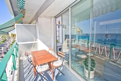 a balcony with a wooden table and chairs on it at Luxury Sea Front Condo Milord in Nice