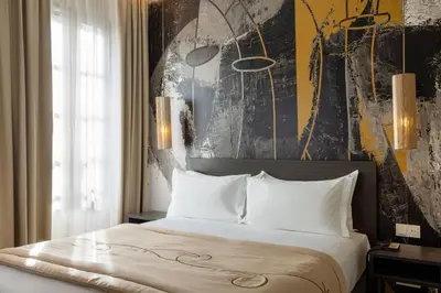 a bedroom with a large bed with white pillows at Palais Ségurane Boutique Hôtel in Nice