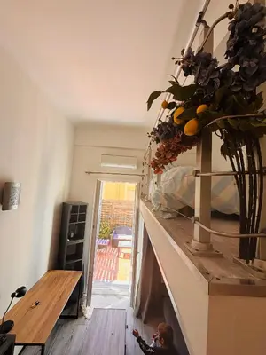 a living room with a counter with a vase of oranges at Berlioz TERRASSE in Nice