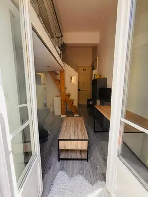 a living room with a wooden table and a room at Berlioz TERRASSE in Nice