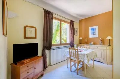 a dining room with a table and a television at Studio charmant à Cagnes-sur-Mer de 35 m² + piscine privée in Cagnes-sur-Mer