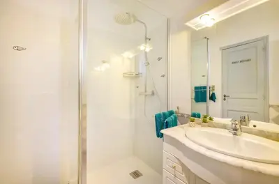 a white bathroom with a sink and a shower at Studio charmant à Cagnes-sur-Mer de 35 m² + piscine privée in Cagnes-sur-Mer