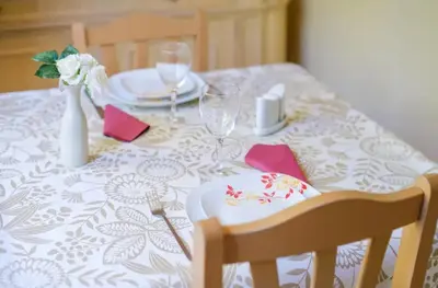 a table with a white table cloth with a plate and wine glasses at Studio charmant à Cagnes-sur-Mer de 35 m² + piscine privée in Cagnes-sur-Mer