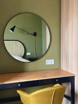 a mirror on a green wall with a yellow chair at Appartement moderne avec une belle vue in Nice