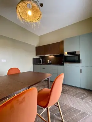 a kitchen with a wooden table and orange chairs at Appartement moderne avec une belle vue in Nice