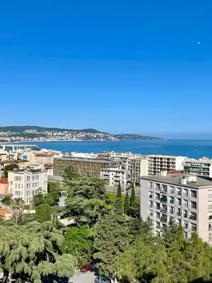 a city with trees and buildings and the ocean at Appartement moderne avec une belle vue in Nice