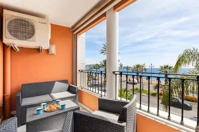 a balcony with a table and chairs and a window at Loft Le Galet FSHH in Nice