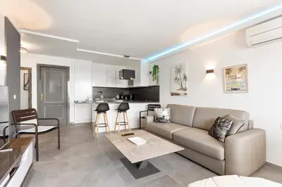a living room with a couch and a kitchen at Loft Le Galet FSHH in Nice